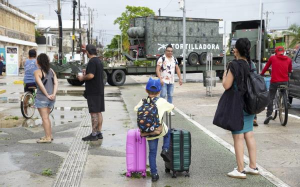 Tourists stand on a street as Mexican army soldiers, members of the DN-III (Natural Disasters) plan, arrive with a mobile kitchen team to assist the population affected by the passage of Hurricane Beryl in Tulum, Quintana Roo State, Mexico, on July 5, 2024. Hurricane Beryl slammed into Mexico's Yucatan Peninsula Friday near the resort town of Tulum with fierce winds, US forecasters said. The Natio<em></em>nal Hurricane Center said the storm was packing maximum sustained winds of 100 mph (160 kph) making it a Category 2 hurricane, weaker than earlier in the week as Beryl hit islands in the Caribbean. (Photo by Elizabeth RUIZ / AFP)