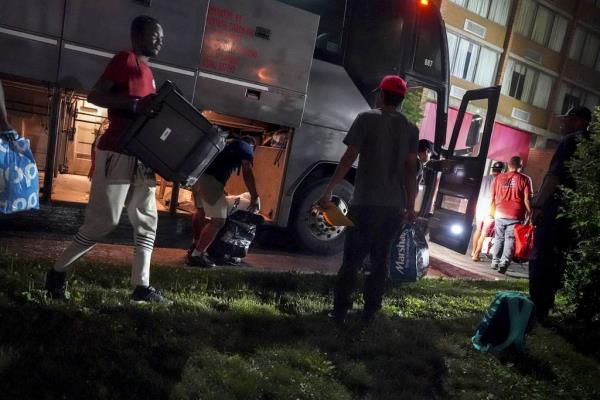 A group of migrants retrieve their belo<em></em>ngings from a bus as they arrive at the Ramada Inn hotel in Albany, N.Y., on July 5, 2023. New York alone has received more than 100,000 migrants in the last year; o<em></em>nly 13,100 were sent on a bus provided by the state of Texas. 