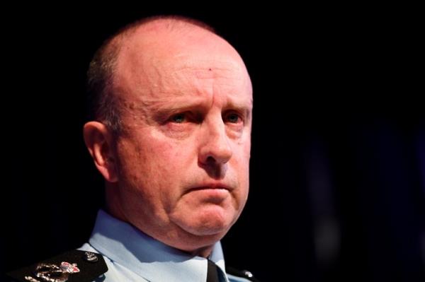 a close up of a man's face he is frowning and wearing a blue police uniform