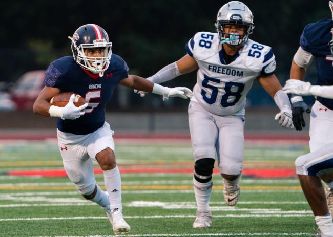 Rancho Cotate running back Geovanny Ortiz, left, slips through Freedom High’s offensive line for a large gain early in the first quarter Friday, Sept. 15, 2023 in Rohnert Park. (Nicholas Vides / For The Press Democrat)