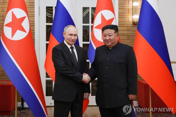 This photo, released by Russia's TASS news agency, shows Russian President Vladimir Putin and North Korean leader Kim Jong-un posing at the Kumsusan State Guest House at their summit on June 19, 2024. (Yonhap) 